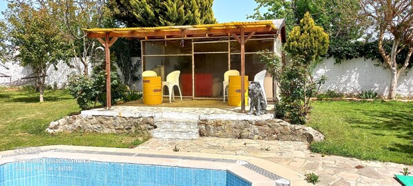 A covered outdoor seating area with a pool in the foreground. - Farm House in Kusadasi (Kusadasi)
