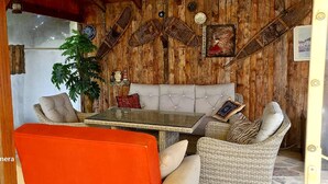 Une pièce chaleureuse avec un mur en bois, un canapé, une table et une chaise.