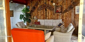 Une pièce chaleureuse avec un mur en bois, un canapé, une table et une chaise.