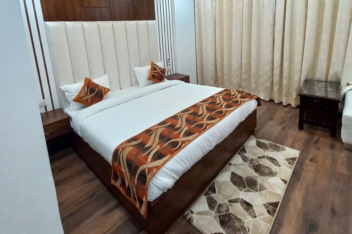 Une chambre moderne avec un lit, des tables de chevet, un ventilateur de plafond et une fenêtre avec des rideaux.