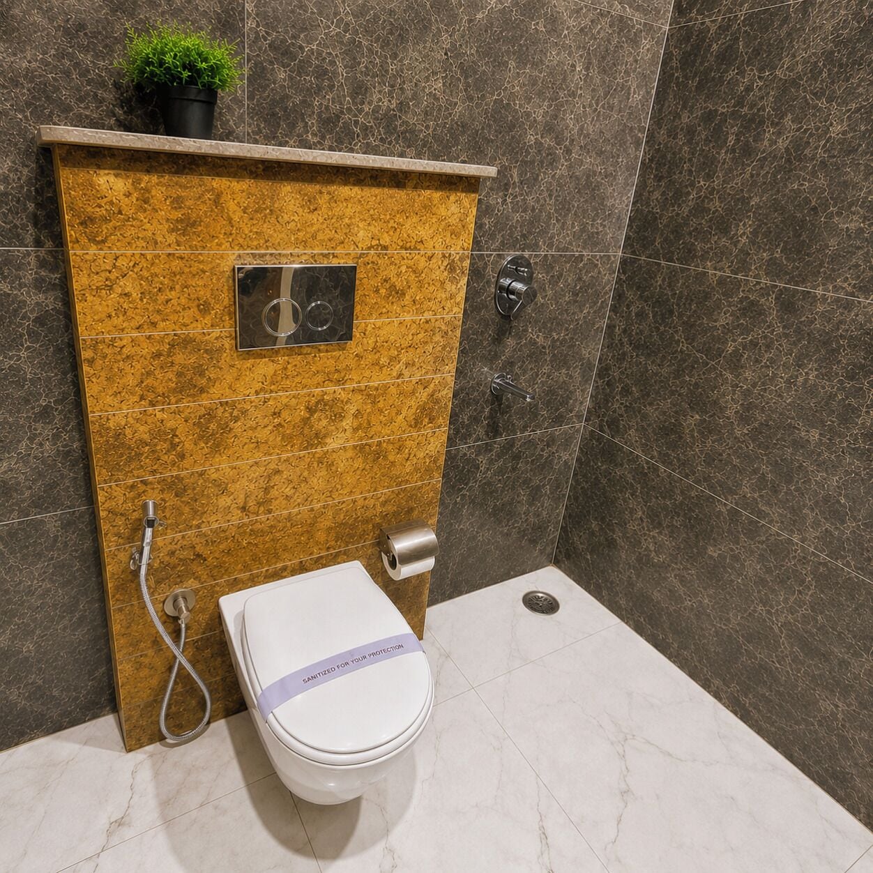 Casa de banho com sanita, chuveiro e porta-toalhas.
