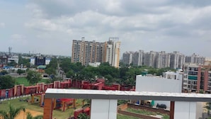 A residential area with high-rise buildings, a playground, and a sports field. - HOTEL The Rich Grand (Agra)