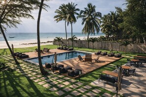 Una piscina al aire libre, sombrillas, sillones reclinables de piscina