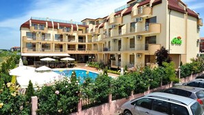 Un hôtel à plusieurs étages doté d’une piscine, d’un espace extérieur aménagé et d’un jardin.