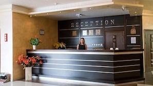 Un comptoir d’accueil sur lequel est affiché un panneau indiquant « RÉCEPTION ».