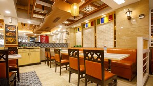 A restaurant interior with booths, wooden chairs, a tiled floor, and a brick wall. - Sangam City Hotel (Kathmandu)