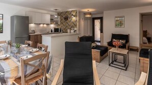 A modern apartment with a dining area, kitchen, and living space. - Chez Béatrice et Pascal by Interhome (Lozari)