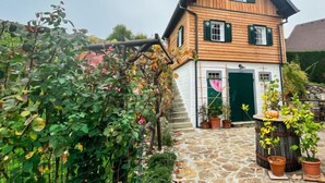 Une maison en bois avec un chemin de pierre menant à l’entrée.