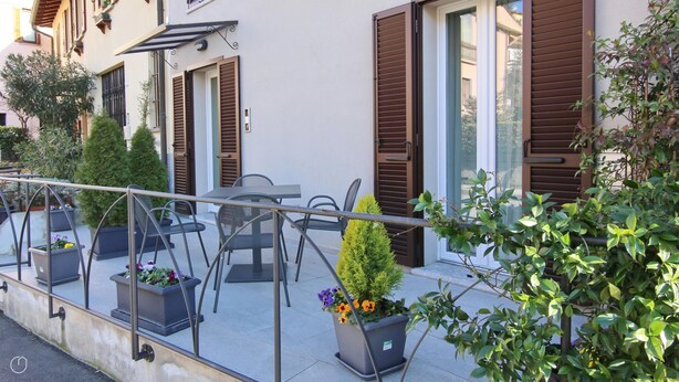 Un balcon aménagé avec du mobilier d’extérieur, des plantes en pot et une rambarde.
