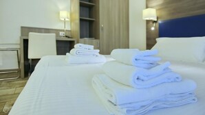 Une chambre d’hôtel avec un lit bien fait, un bureau et une chaise.