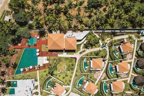 Eine Luftaufnahme eines Resorts mit mehreren Swimmingpools, Palmen und Hotelgebäuden.