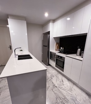 Een moderne keuken met een centraal eiland, geïntegreerde apparatuur en een strak design.