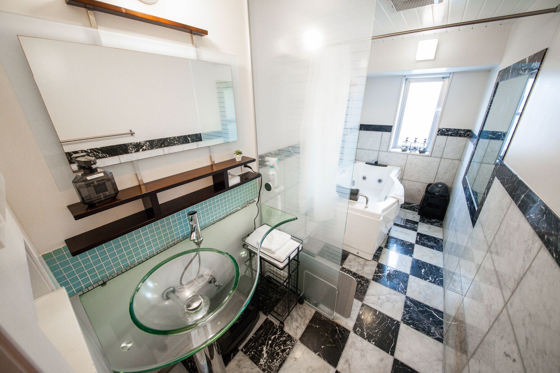 A modern bathroom with a glass sink, a white toilet, and a shower area.