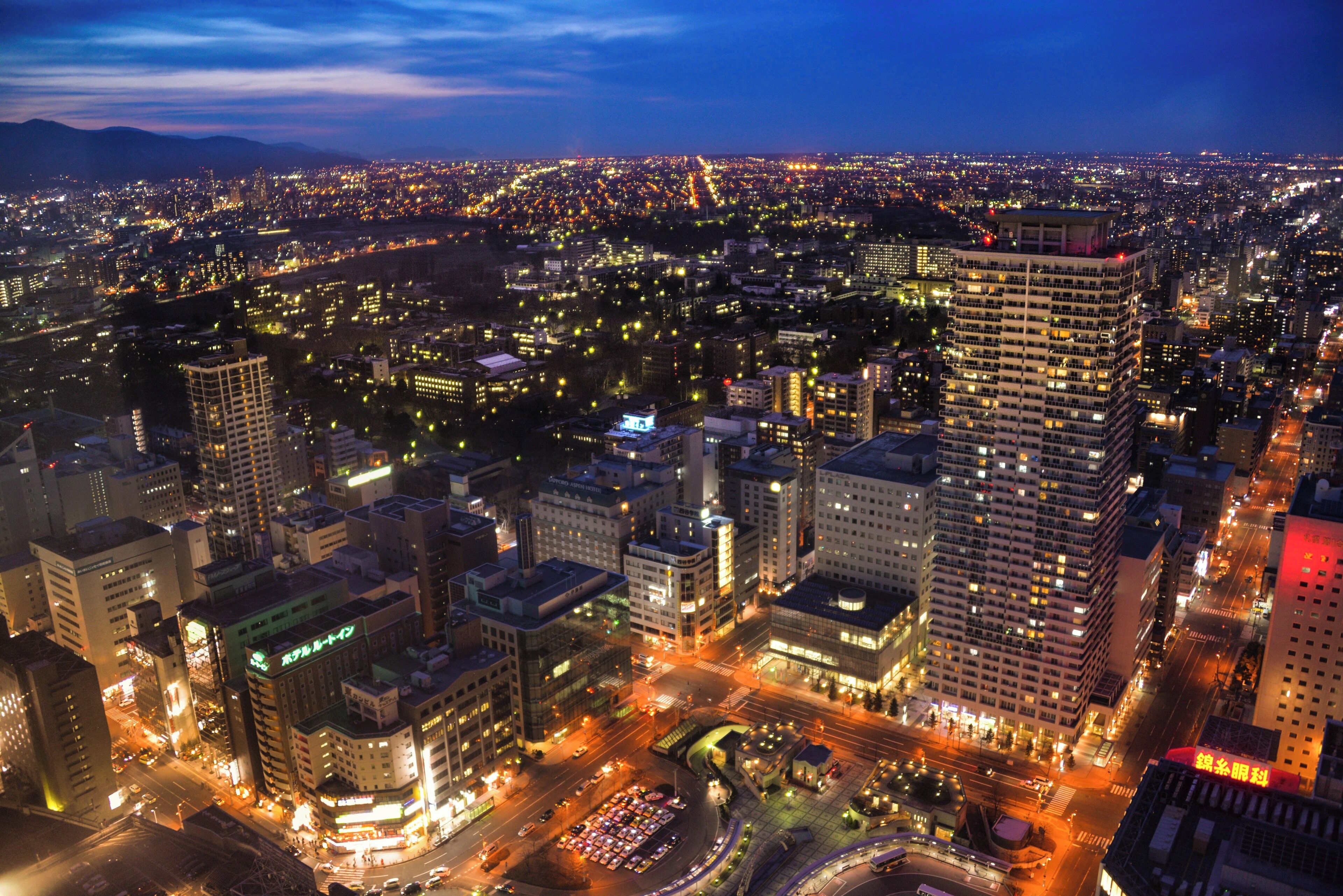 A nighttime cityscape with illuminated buildings and streets.