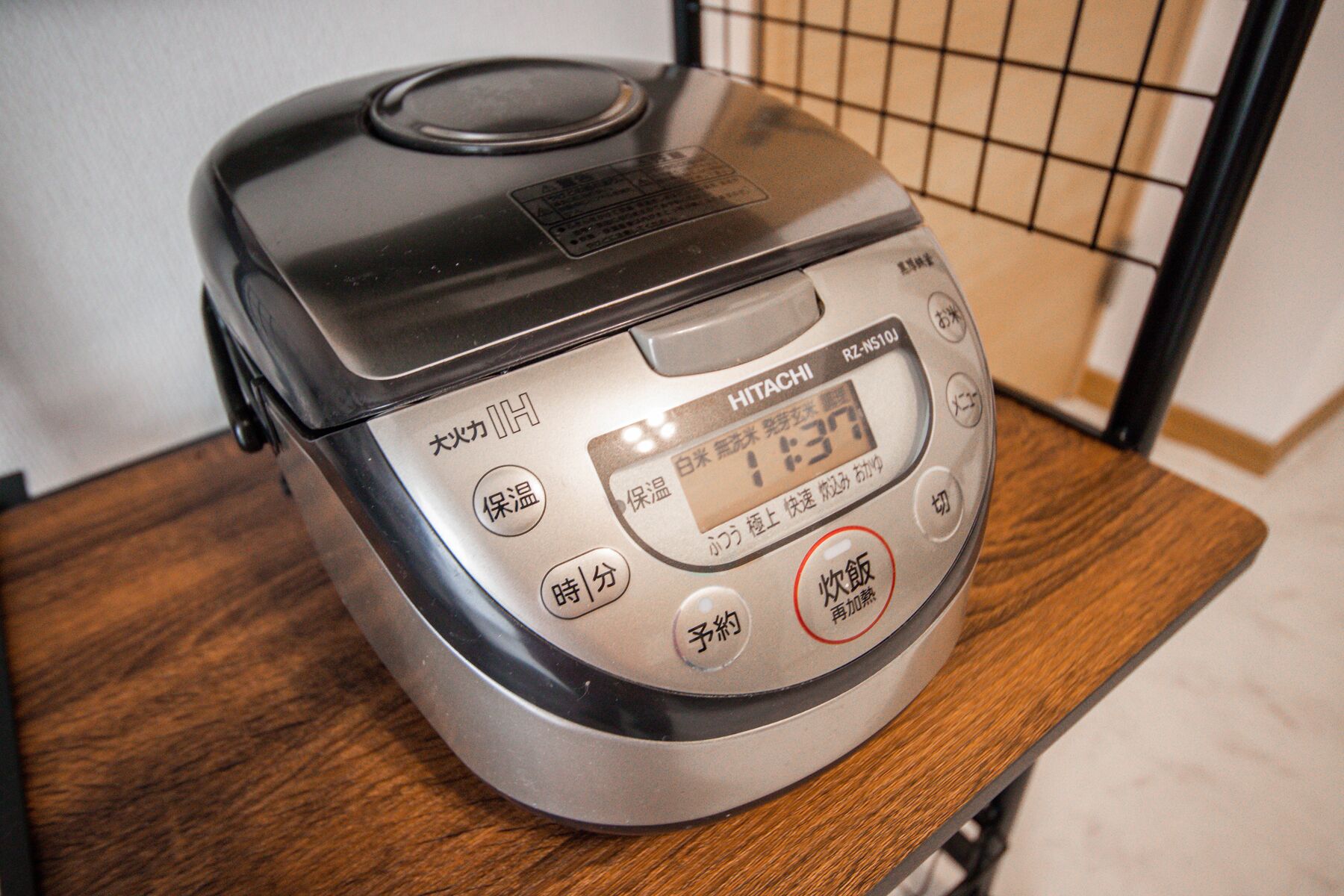 A rice cooker with Japanese labels and a digital display.