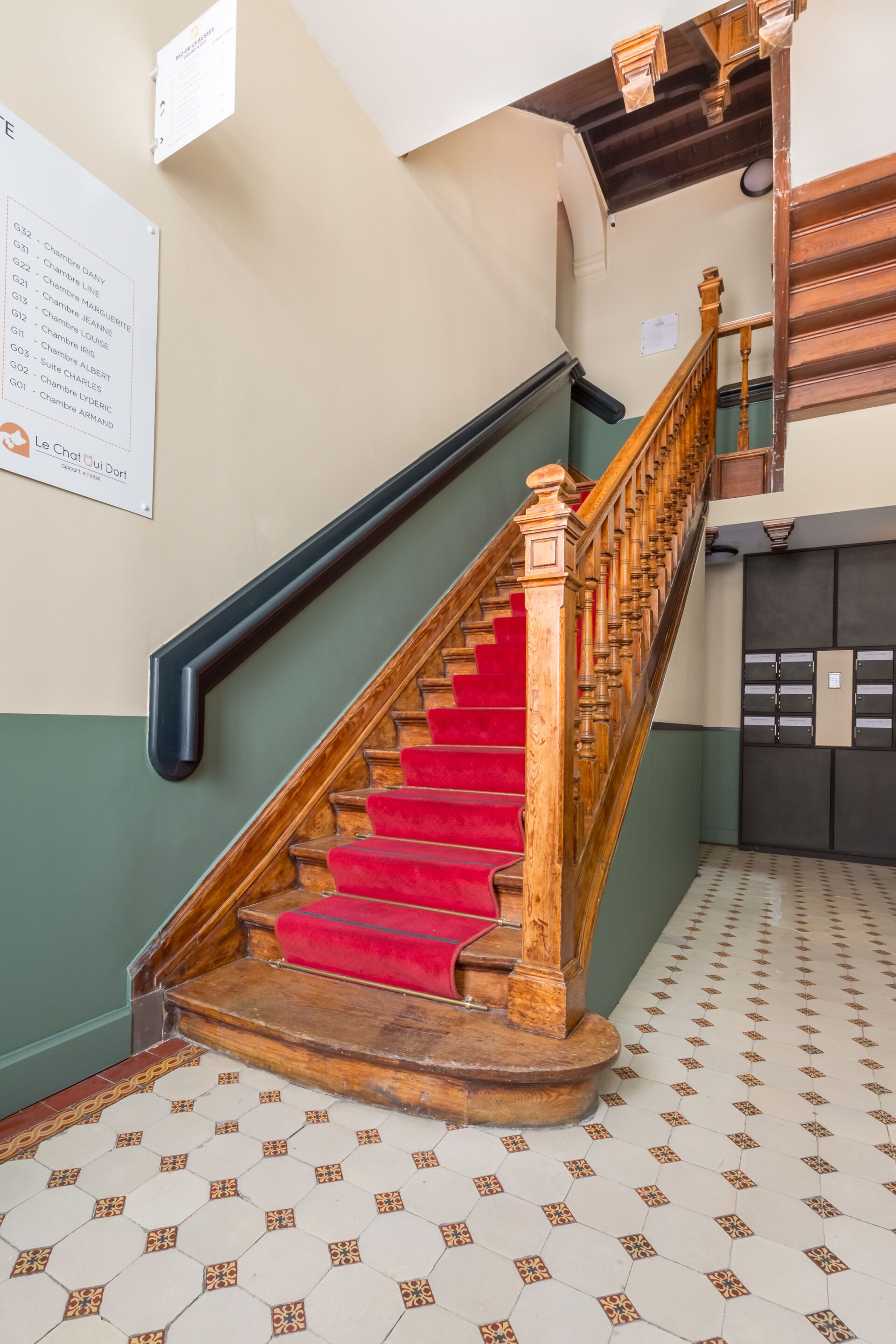 A staircase with red carpeted steps and wooden balusters.