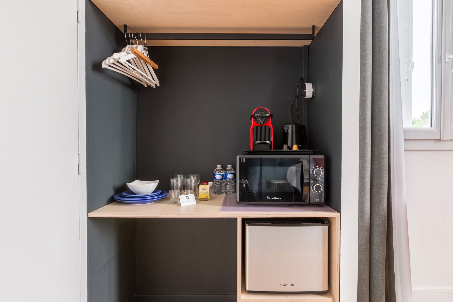 A compact kitchenette with a microwave, a small refrigerator, and a coffee maker.