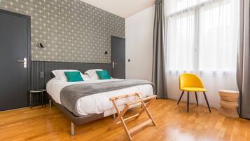 Quarto moderno com uma cama, escada de madeira, cadeira amarela e uma pequena mesa.