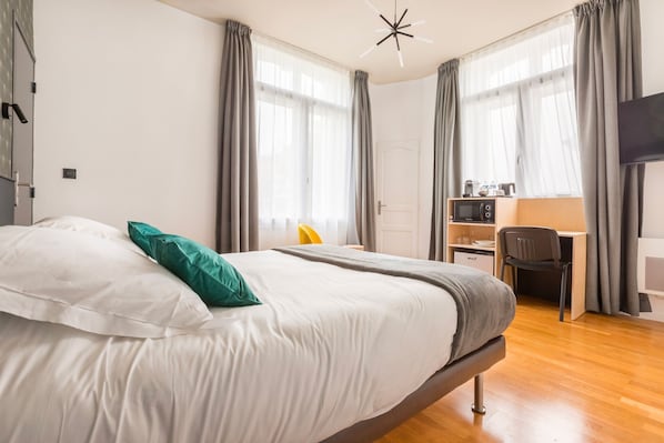 A modern hotel room with a large bed, a desk with a chair, and a television. - Au Chat Qui Dort Lille - Villa Gounod (Lille)