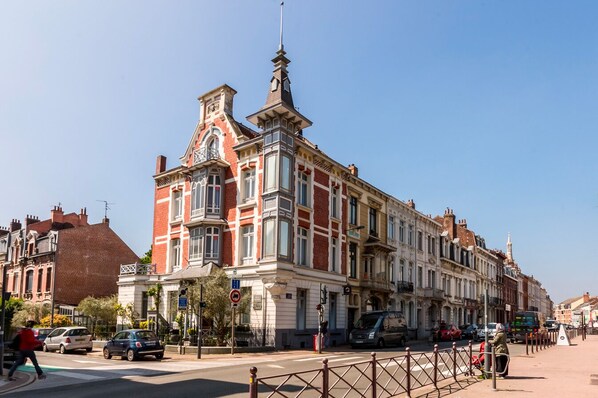 Un edificio histórico con una destacada torre de reloj, ventanas amplias y un estilo arquitectónico clásico.