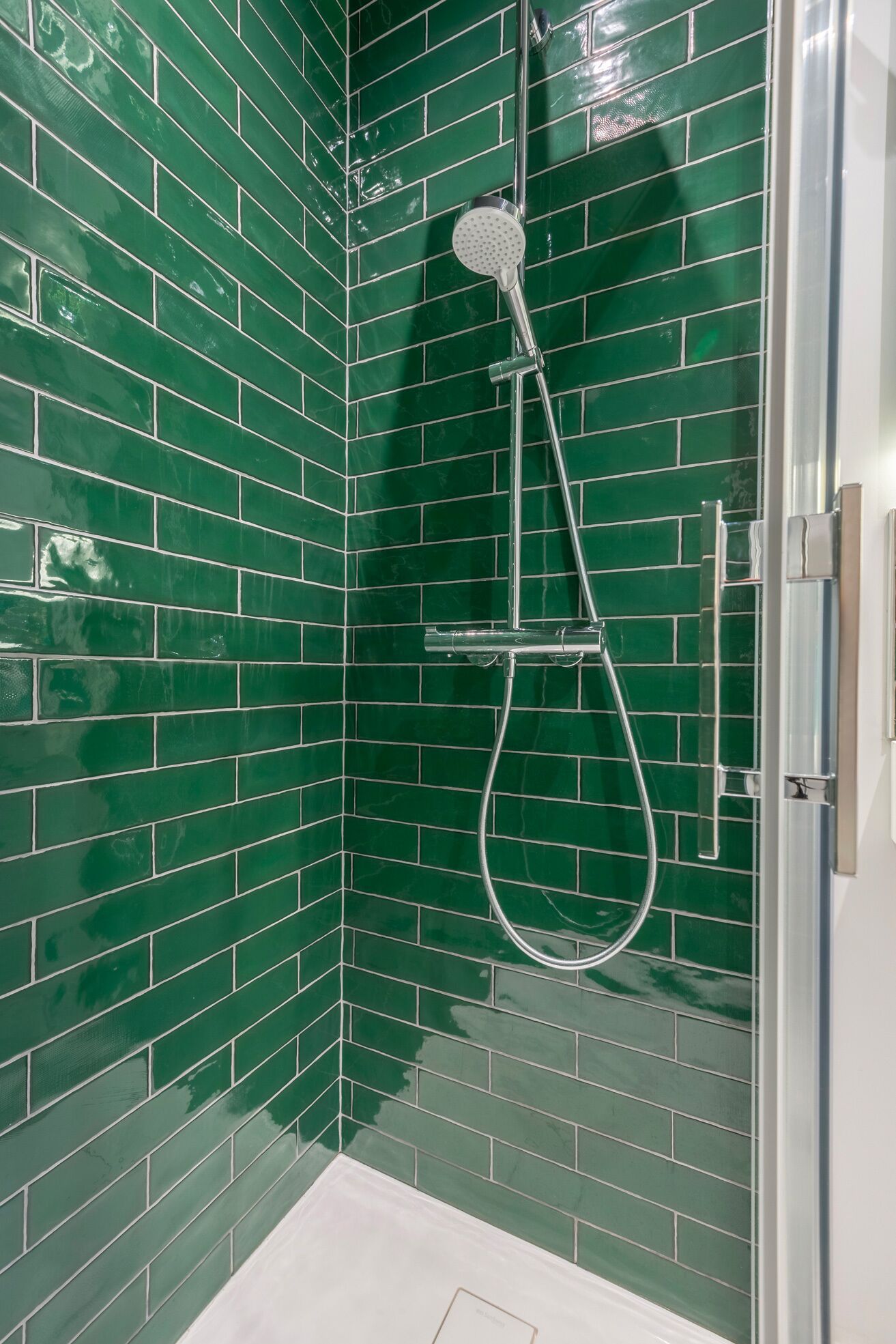 Eine Dusche mit Duschkopf und Handbrause.