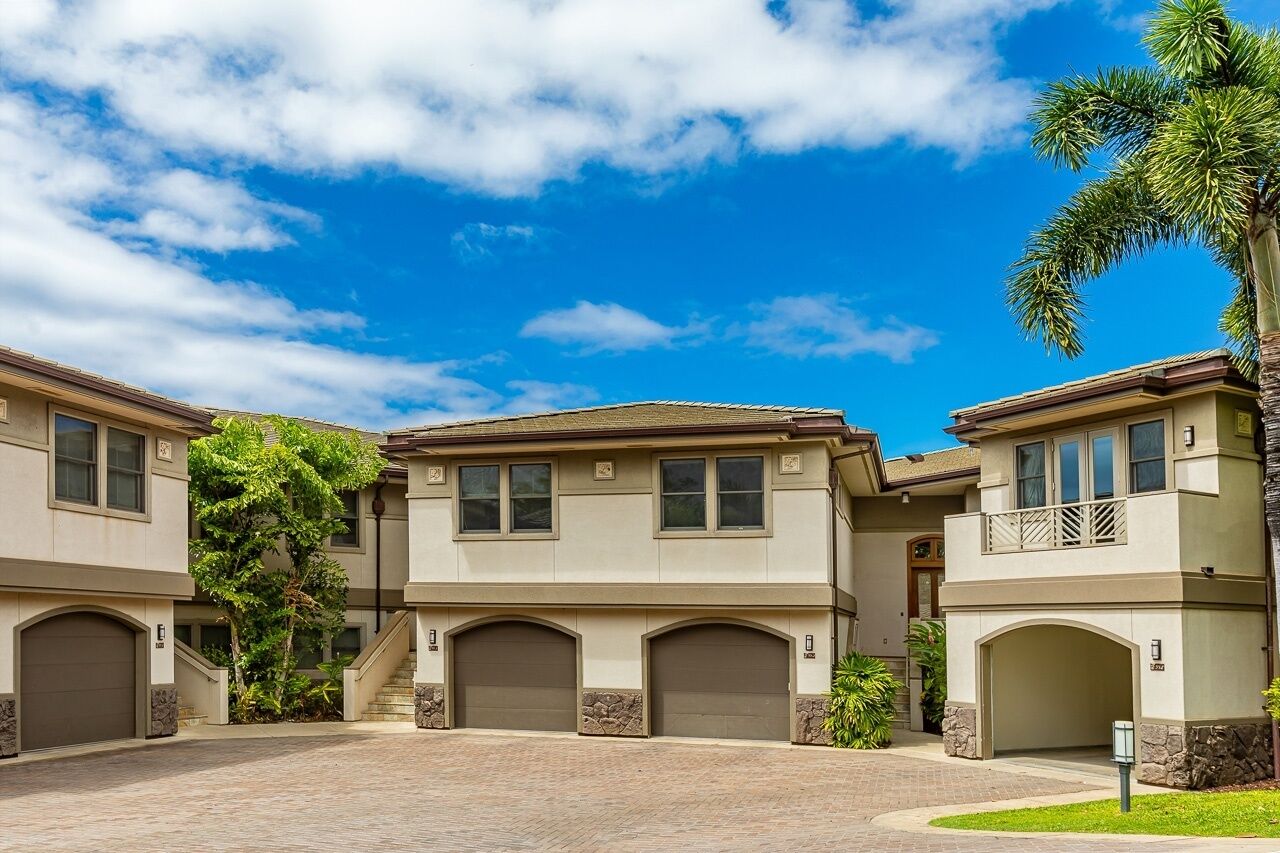 A residential building with a central entrance, two-story structure, and a covered driveway.