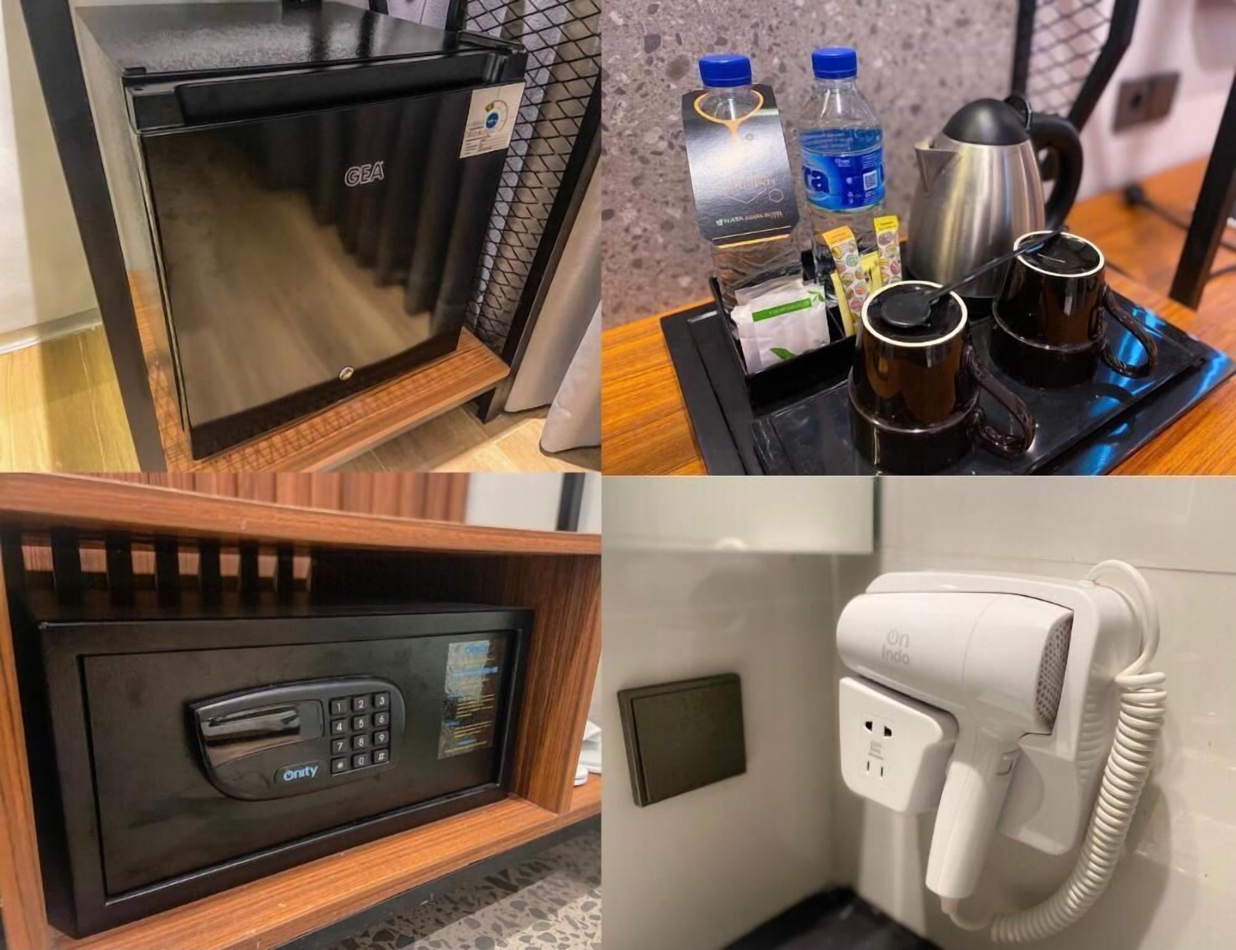 A GEA microwave, a water bottle, a coffee maker, and a hairdryer in a hotel room.