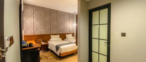 A hotel room with a bed, bedside table, and a wardrobe.