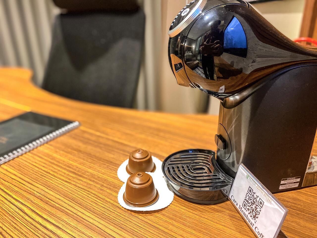 A coffee machine with a QR code on a wooden table.
