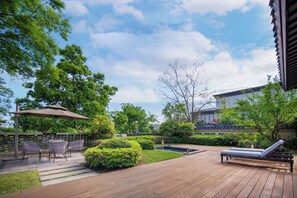 A wooden deck with outdoor furniture, a small water feature, and lush greenery. - Song Hotel Chengdu Qingcheng  (Chengdu)