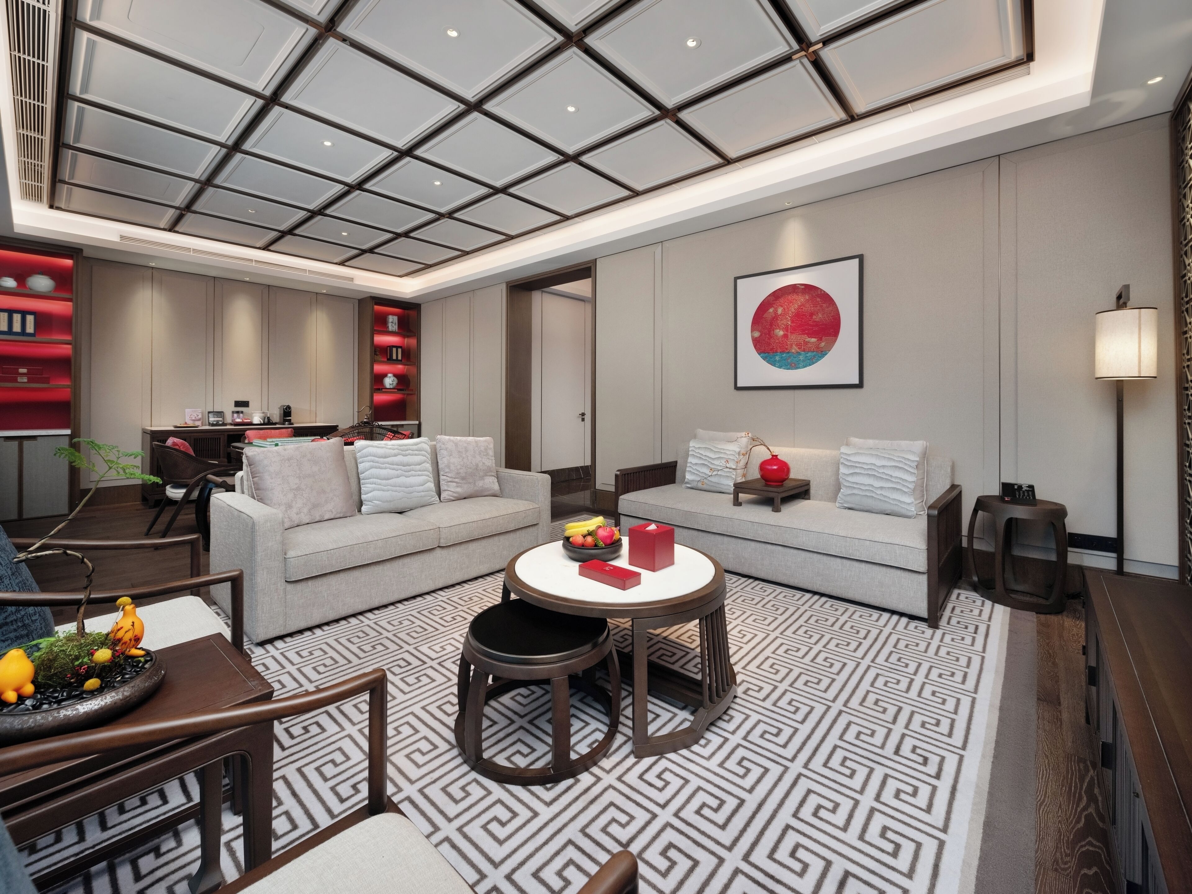 A modern living room with a sofa, a coffee table, and a dining area with a table and chairs.