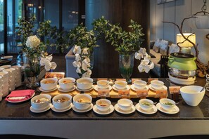 A buffet setup with various dishes and a green pot on a counter. - Song Hotel Chengdu Qingcheng  (Chengdu)