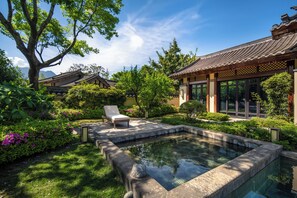 A traditional building with a tiled roof, a swimming pool, and a chair in the garden. - Song Hotel Chengdu Qingcheng  (Chengdu)
