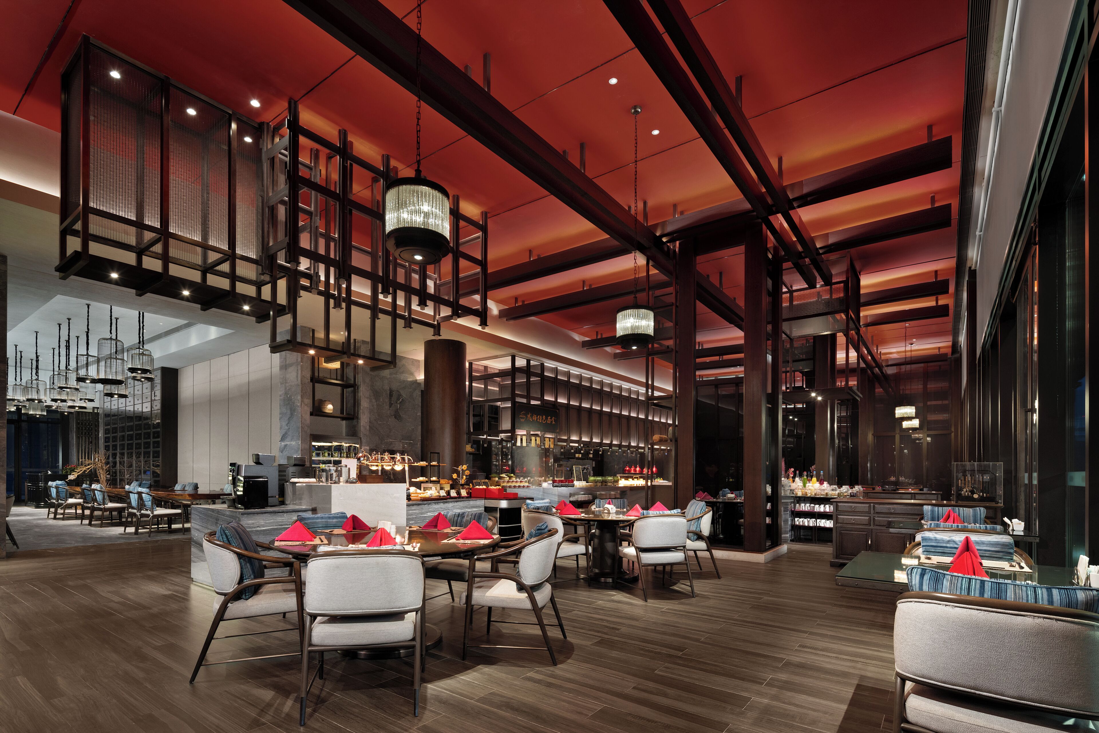 A modern restaurant with high ceilings, exposed beams, and contemporary lighting fixtures.