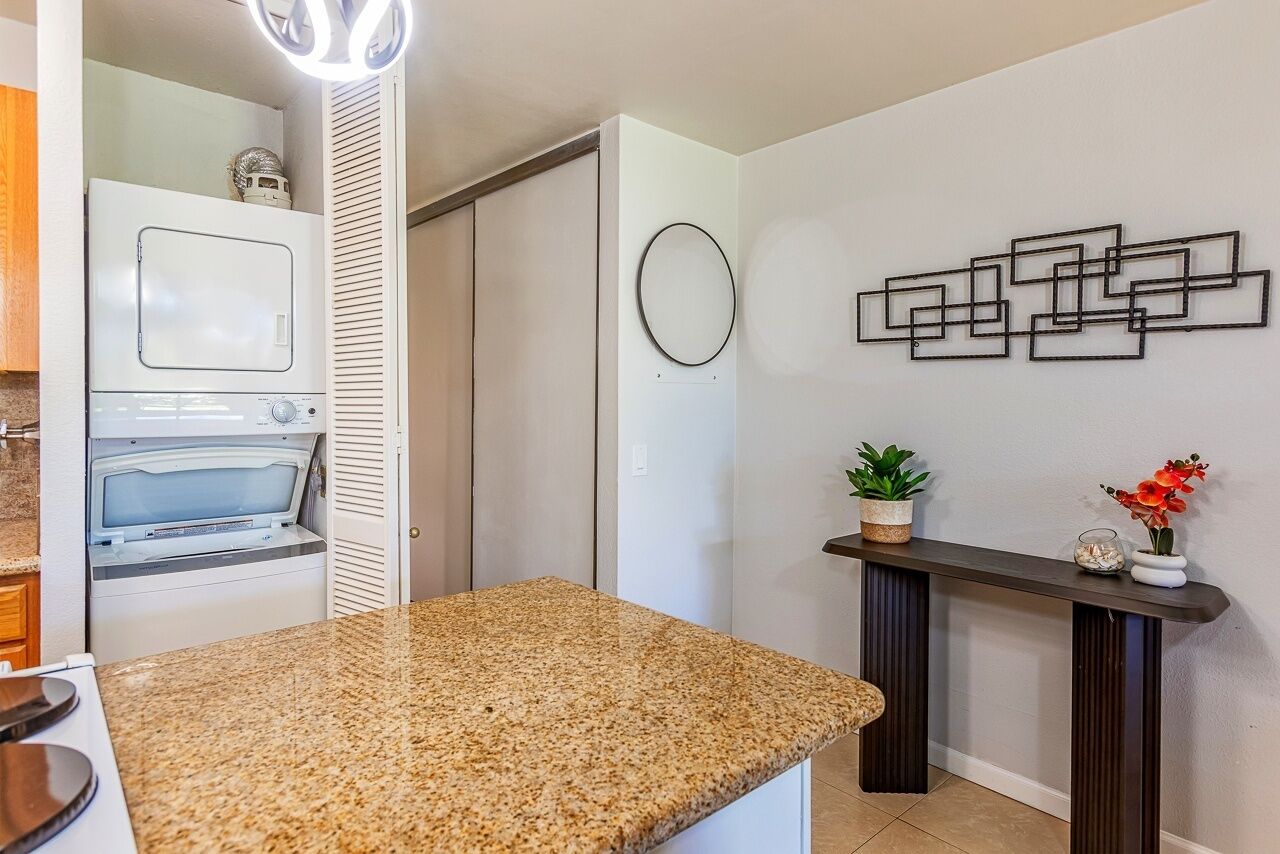 A kitchen with a granite countertop, a built-in oven, and a wall-mounted decorative piece.