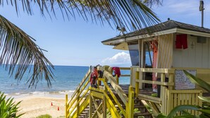 A lifeguard tower with a sign, wooden stairs, and a beach view. - Maui Parkshore by Coldwell Banker Island Vacations (Kihei)