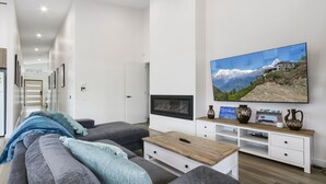 A modern living room with a sofa, coffee table, TV, and decorative items.