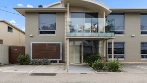 Un bâtiment à deux étages doté de grandes fenêtres, d’une entrée abritée et d’un petit jardin.