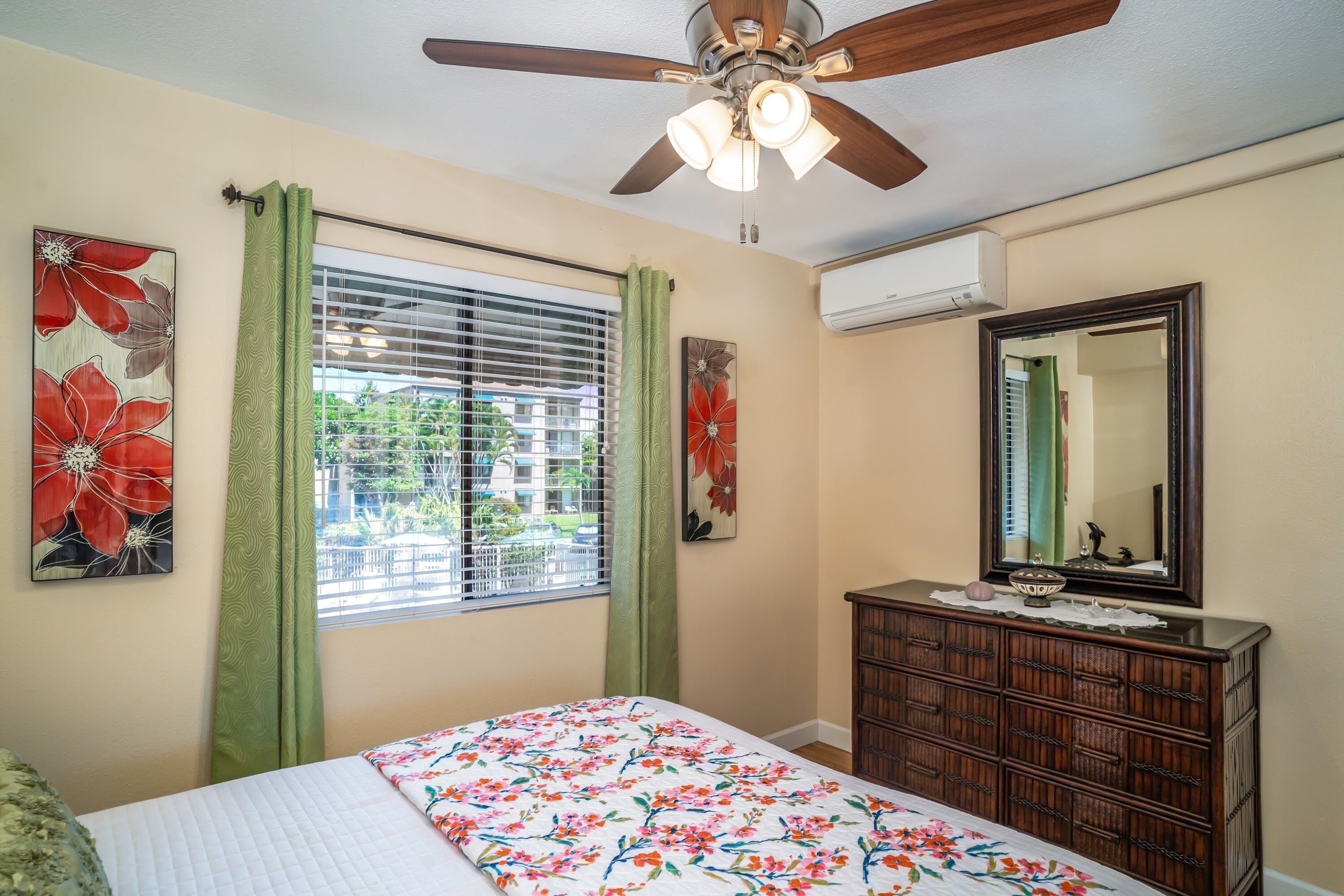 A bedroom with a bed, a dresser, a ceiling fan, and a window with blinds.