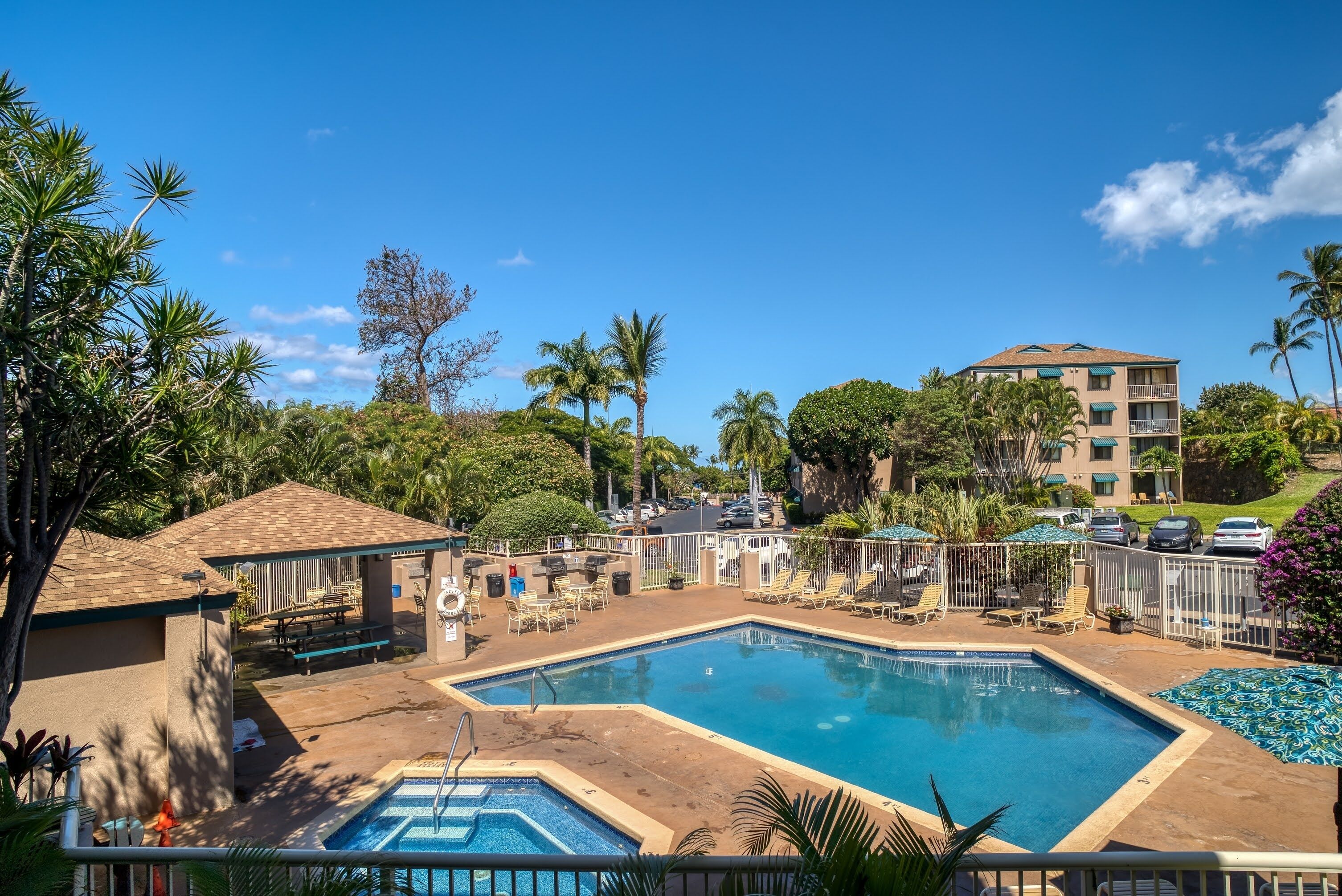 A pool area with lounge chairs and a building in the background.