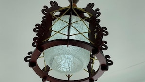 Un candelabro con pantalla de cristal geométrico y estructura de metal oscuro.