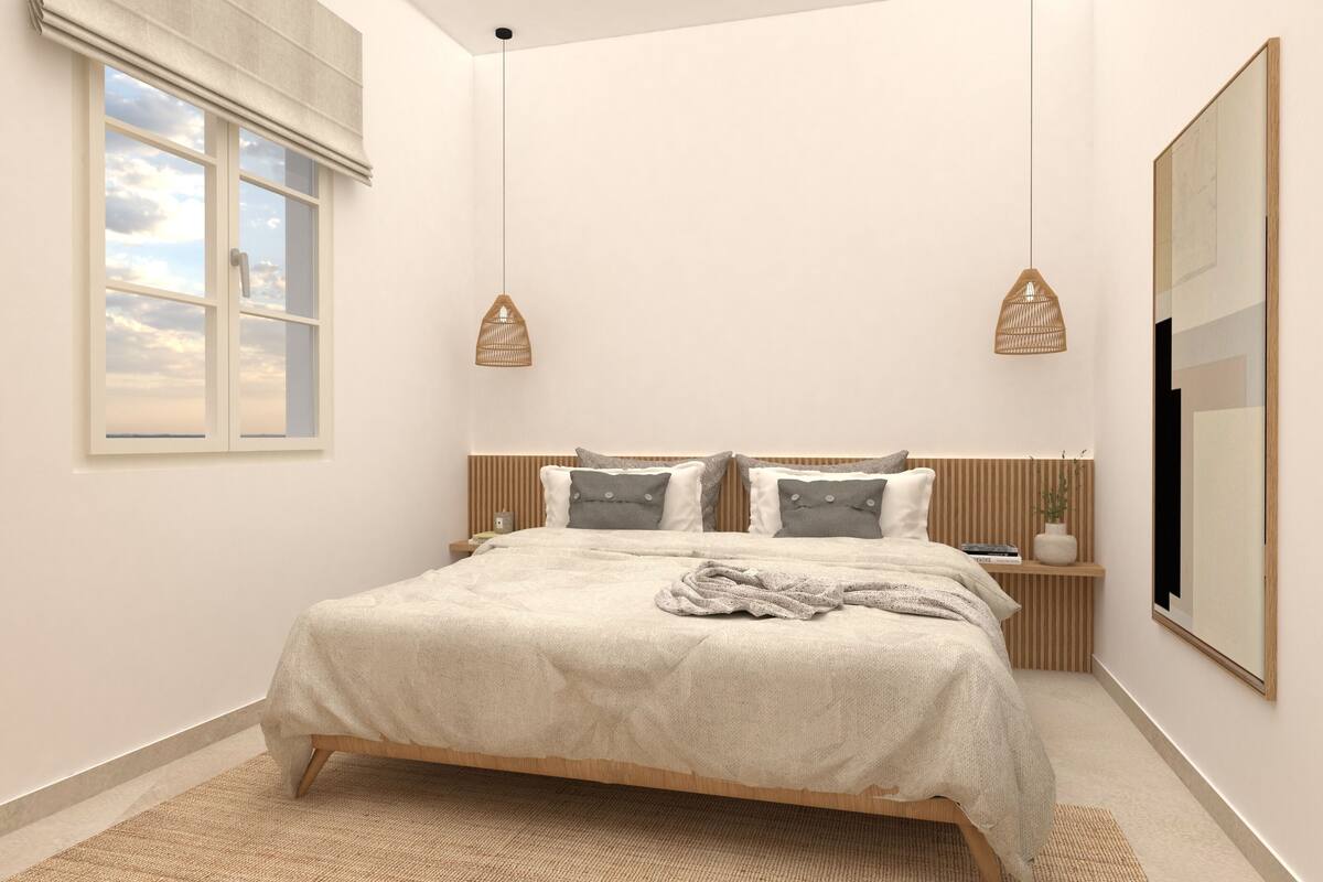 Een slaapkamer met een bed, nachtkastjes, een raam en een aan de muur bevestigde televisie.