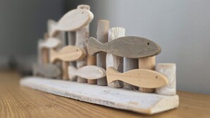 A wooden fish sculpture on a rustic shelf. - Doppelhaushälfte für 6 Personen mit Wlan (Graal-Müritz)