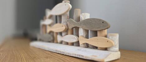 A wooden fish sculpture on a rustic shelf.