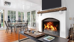 A modern living room with a fireplace, dining area, and large windows. - Glen Regan, Berrima, Southern Highlands (Berrima)