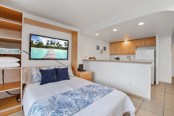 Un dormitorio con cama, televisión y vista a la playa.