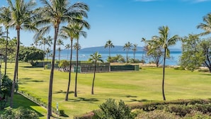 Ein Golfplatz mit Palmen und Blick auf den Ozean.