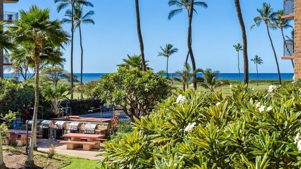 Ein Resort mit Poolbereich, Palmen und Blick auf den Ozean.