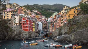 A coastal village with colorful buildings and boats docked in the water.