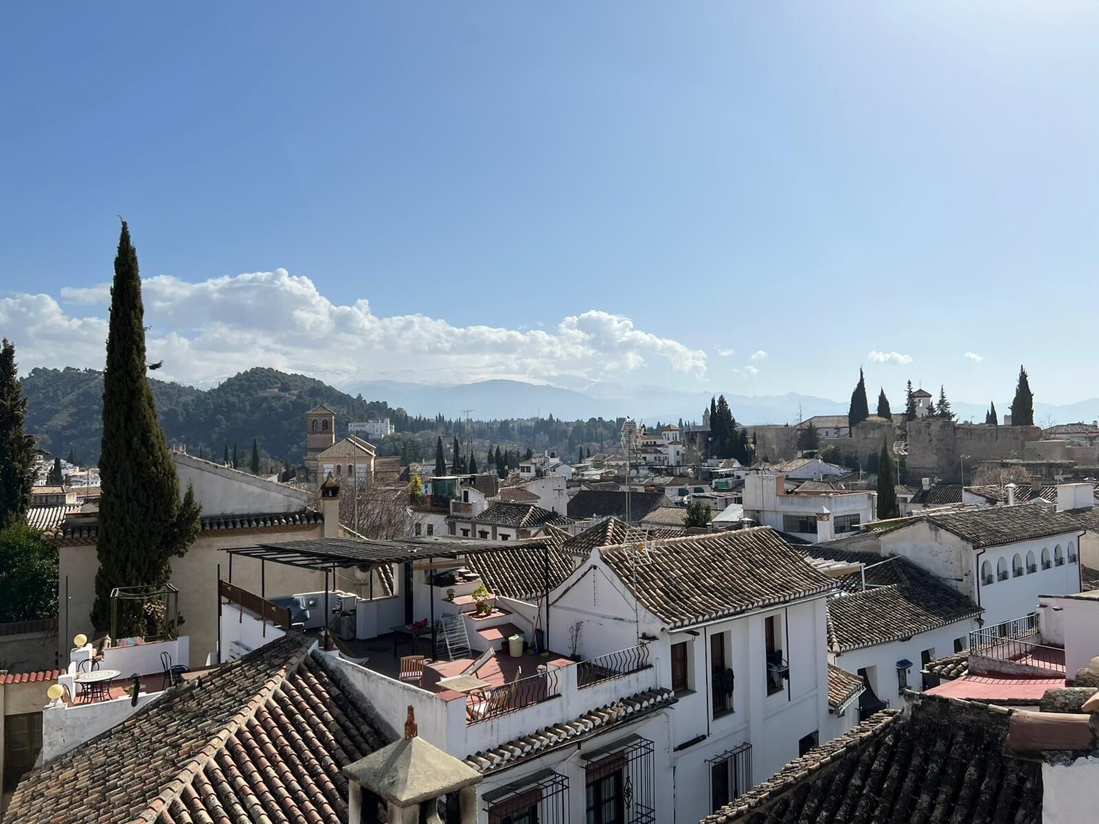 A view of a town with traditional architecture, including terracotta-tiled roofs and white-washed buildings.